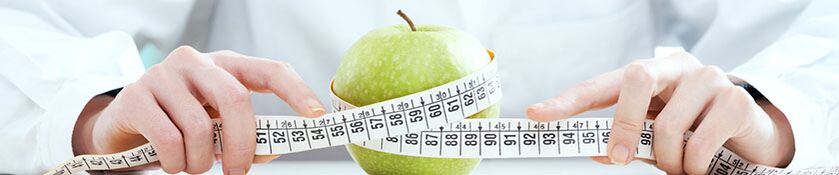 The girl measures the apple with an centimeter band